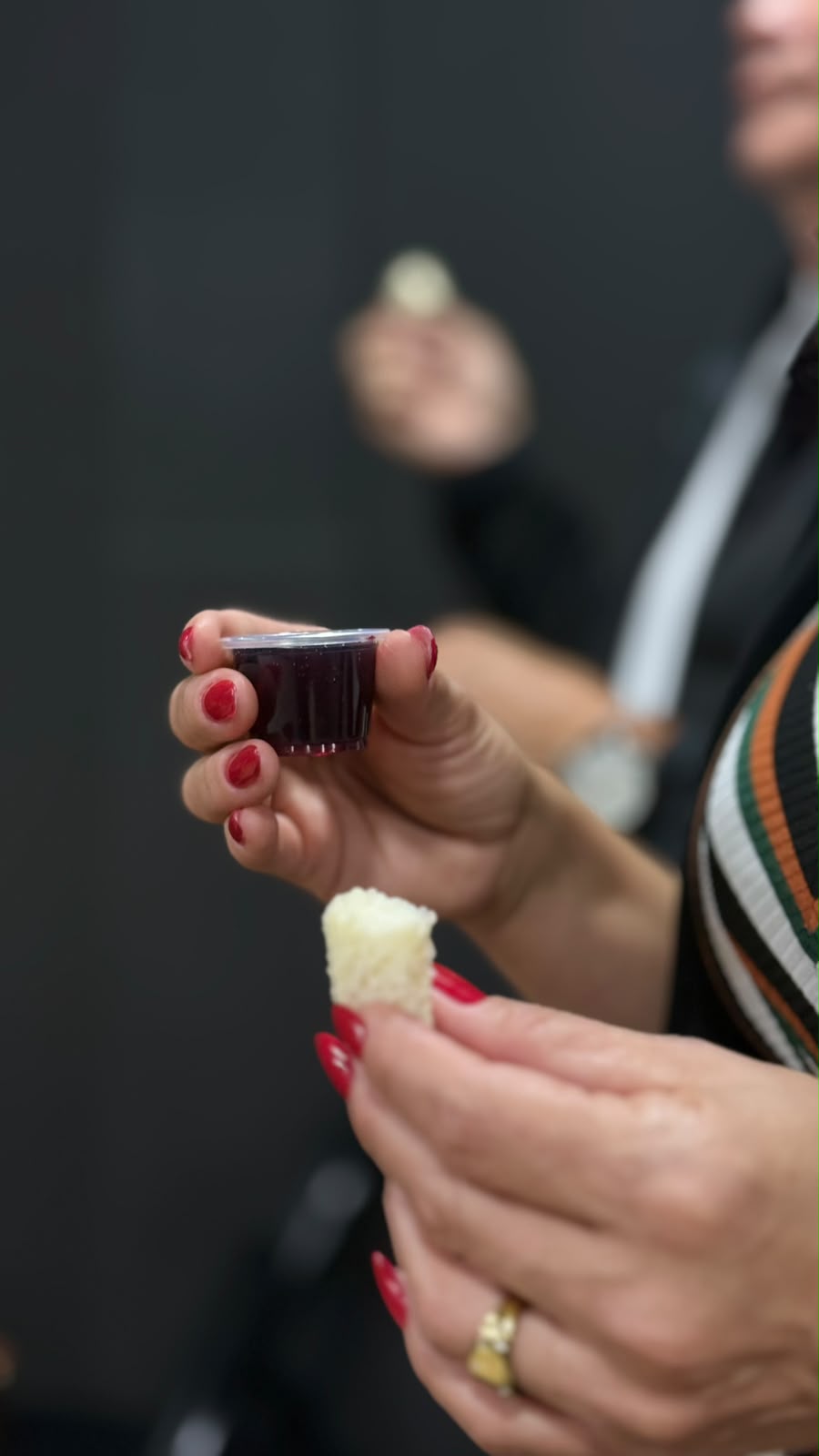 Mãos a segurar o pão e o cálice da Santa Ceia