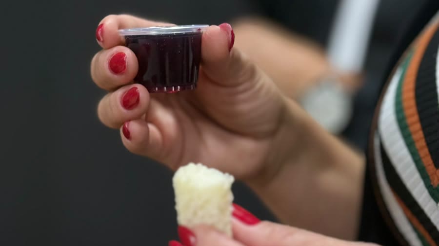 Mãos a segurar o pão e o cálice da Santa Ceia